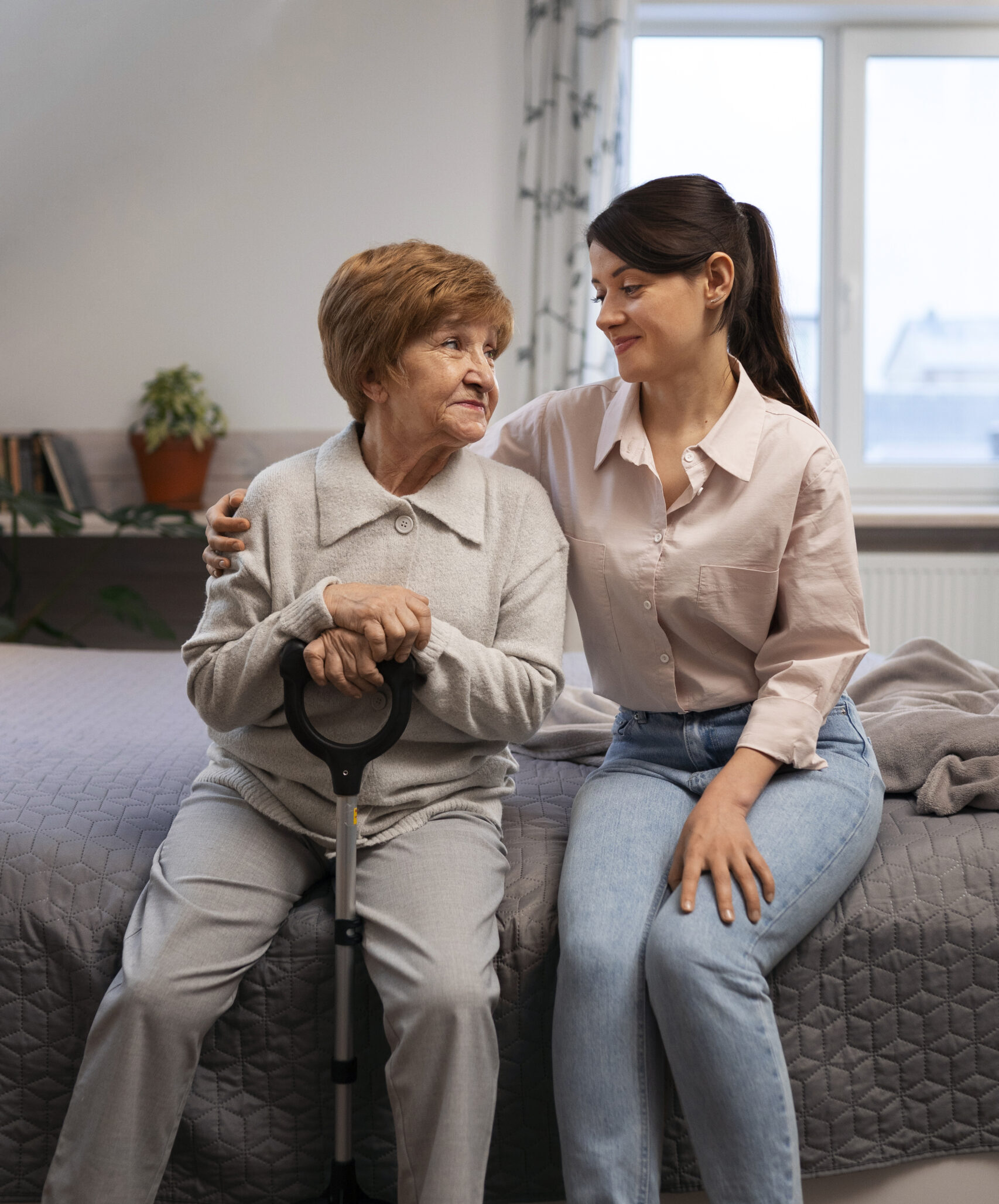 Caregiver sitting with an elderly woman while providing personalized senior care assistance in Fulton County, GA