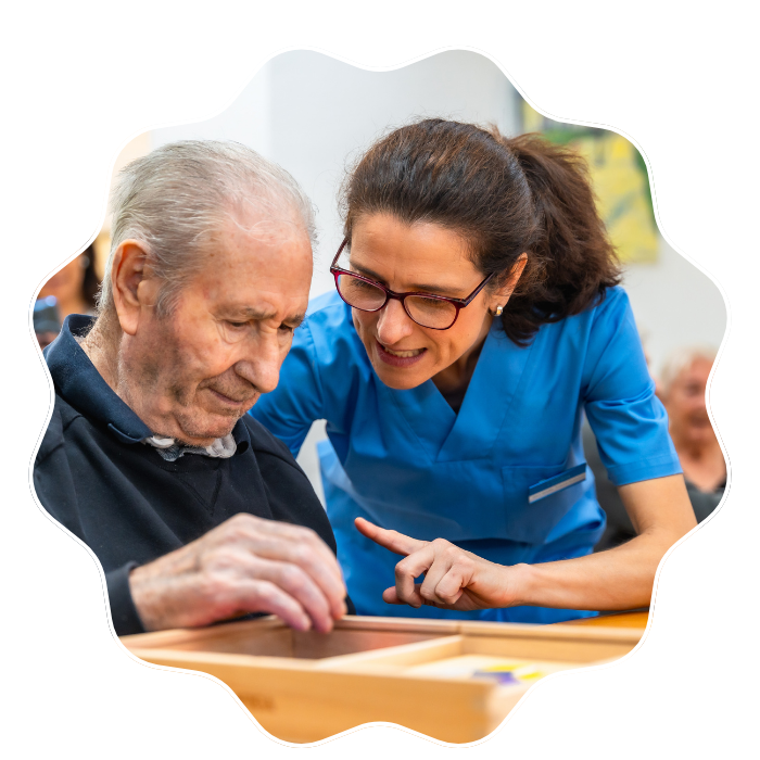 Caregiver assisting a senior man with cognitive activities and compassionate memory care support in Fulton County, GA