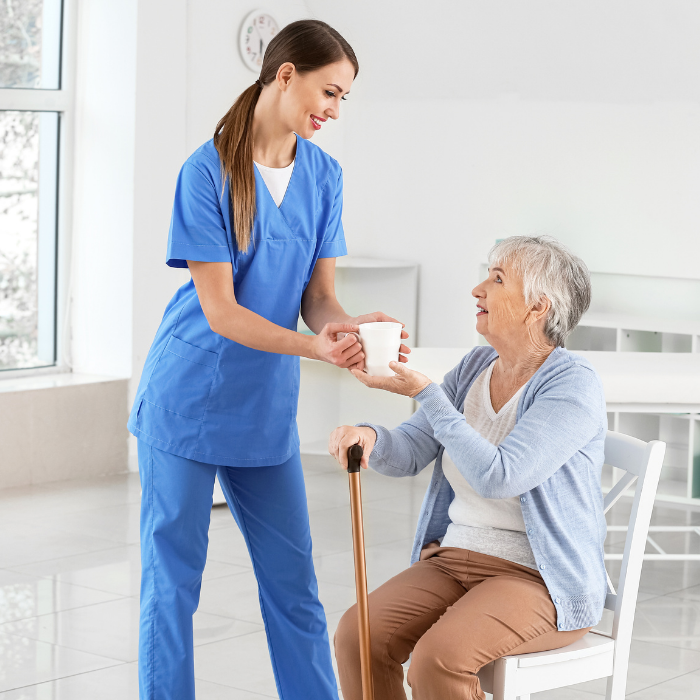 Caregiver helping a senior woman with daily mobility and Parkinson’s support assistance in Fulton County, GA